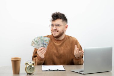 Genç ve mutlu muhasebeci masasında oturup paraları sayıyor. Yüksek kalite fotoğraf