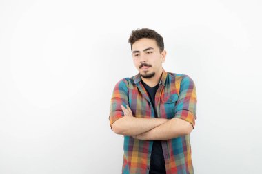 Damalı tişörtlü, kolları çapraz duran yakışıklı bir adam resmi. Yüksek kalite fotoğraf