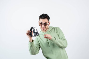 Gözlüklü yakışıklı bir adam kulaklığa bakıyor. Yüksek kalite fotoğraf