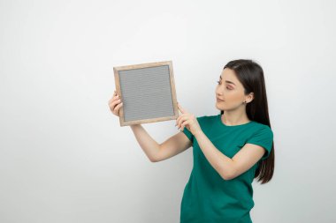 Beyaz duvarın karşısında el ele tutuşmuş güzel bir kadının portresi. Yüksek kalite fotoğraf