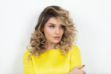 güzel genç kadın kıvırcık saçlı beyaz arka plan üzerinde poz