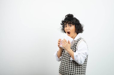 Beyaz arka planda patlamış mısırla kovayı tutan genç bir kız. Yüksek kalite fotoğraf