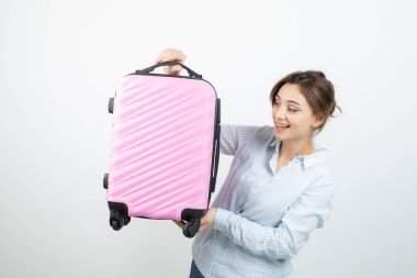 Kadın turist ayakta ve elinde pembe bir valiz tutuyor. Yüksek kalite fotoğraf