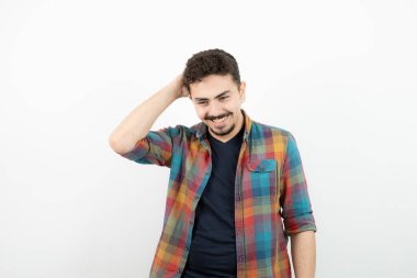 Kareli tişörtlü, başının arkasından el ele tutuşan yakışıklı bir genç resmi. Yüksek kalite fotoğraf