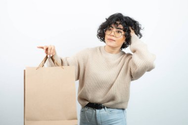 Esmer bir kadının gözlüklü hali. Elinde el işi çantaları var. Yüksek kalite fotoğraf