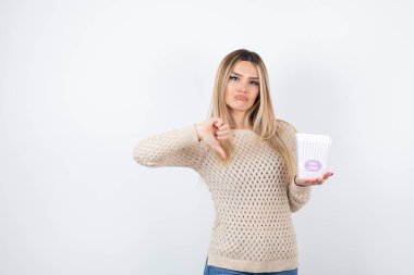 Parmağını aşağı gösteren ve elinde patlamış mısır olan genç bir kadın resmi. Yüksek kalite fotoğraf