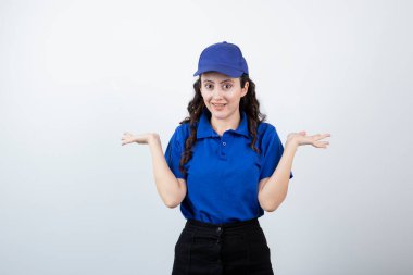 Mavi üniformalı, omuzlarını silken genç bir teslimatçı kadın. Yüksek kalite fotoğraf