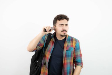 Sırt çantalı ve mikrofonlu genç bir adamın fotoğrafı. Yüksek kalite fotoğraf