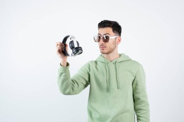 Gözlüklü yakışıklı bir adam kulaklığa bakıyor. Yüksek kalite fotoğraf