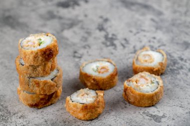 Kayadan bir arka planda sıcak kızarmış suşi ruloları. Yüksek kalite fotoğraf