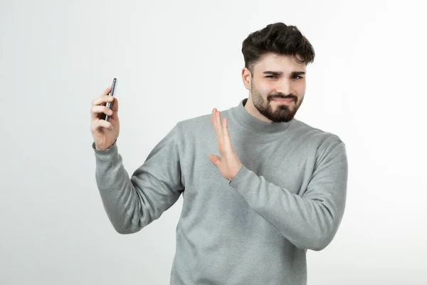 Portret Atrakcyjnego Faceta Trzymającego Smartfon Pod Białą Ścianą Wysokiej Jakości — Zdjęcie stockowe