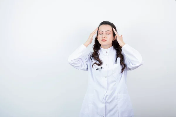Médica Uniforme Segurando Cabeça Contra Parede Branca Foto Alta Qualidade — Fotografia de Stock
