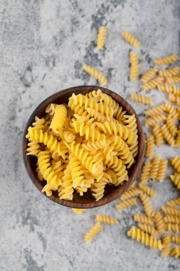 Taş yüzeyinde ahşap fusilli makarna kasesi. Yüksek kalite fotoğraf