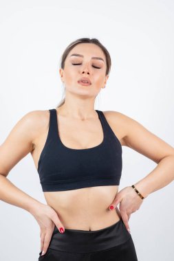 Siyah tarlada dikilmiş poz veren formda genç bir kadın resmi. Yüksek kalite fotoğraf