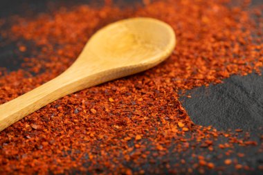 Kırmızı biber yığını ve siyah üzerine ahşap kaşık. Yüksek kalite fotoğraf