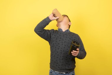 Down sendromlu şirin bir çocuğun sarı yerine bir fincan kahve içtiği fotoğraf. Yüksek kalite fotoğraf