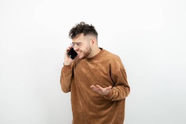 Beyaz duvardan genç bir adamın telefon görüşmesi yaptığı fotoğraf. Yüksek kalite fotoğraf