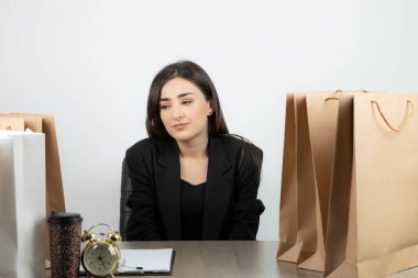 İş kadını iş yerinde elinde dosya ve bir bardak içkiyle oturuyor. Yüksek kaliteli fotoğraf.