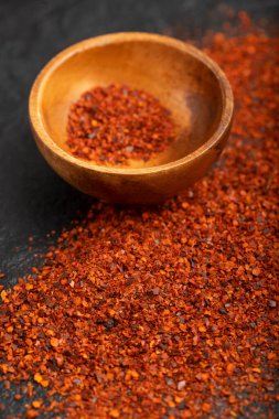 Kara yüzeyde ahşap kase ve kırmızı arnavut biberi. Yüksek kalite fotoğraf