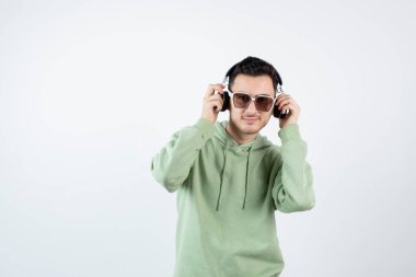 Gözlüklü yakışıklı bir adamın kulaklıkla poz verişi. Yüksek kalite fotoğraf