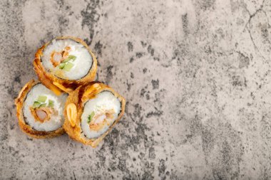 Taş bir masaya salatalık ve pilav konmuş lezzetli suşi ruloları. Yüksek kalite fotoğraf