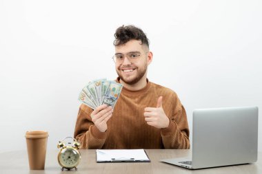 Genç ve mutlu muhasebeci masasında oturup paraları sayıyor. Yüksek kalite fotoğraf