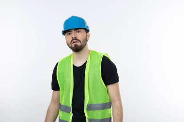 Mavi miğferli genç inşaat işçisinin beyaz kaskın üzerinde durması. Yüksek kalite fotoğraf