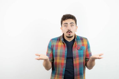 Kareli tişörtlü, omuzlarını silken genç yakışıklı bir adam. Yüksek kalite fotoğraf