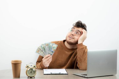 Ciddi bir muhasebeci masasında oturmuş paraları sayıyor. Yüksek kalite fotoğraf