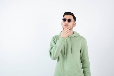 Gözlüklü genç ve yakışıklı bir adamın ayakta durup düşünmesi. Yüksek kalite fotoğraf