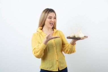 Sarışın kadın beyaz şalgamların üzerinde duran beyaz şalgamlara bakıyor. Yüksek kalite fotoğraf