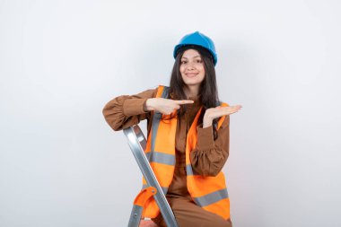 Miğferli kadın mühendis beyaz merdivenin üstünde duruyor. Yüksek kalite fotoğraf