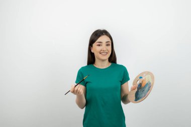 Renkli fırça ve palet kullanan genç, güzel bir sanatçı. Yüksek kalite fotoğraf