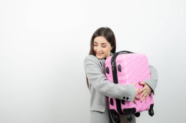Pembe valizli çekici bir kadının fotoğrafı. Yüksek kalite fotoğraf
