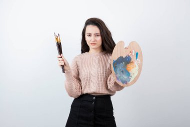 Renkli palet ve fırça tutan genç kadın ressamın portresi. Yüksek kalite fotoğraf