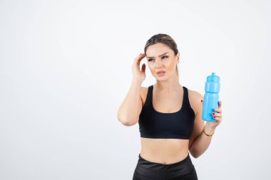 Su şişeli spor elbiseli genç bir kadın.