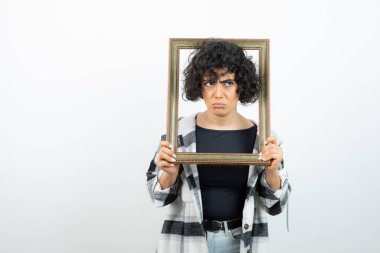 Esmer, güzel bir kadın, elinde eski, ahşap bir çerçeve tutuyor. Yüksek kalite fotoğraf