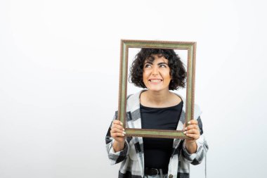 Esmer, güzel bir kadın, elinde eski, ahşap bir çerçeve tutuyor. Yüksek kalite fotoğraf