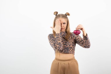 Üstünde kırmızı soğan tutan, kırpık bluzlu genç bir kadın resmi. Yüksek kalite fotoğraf