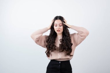 Kafasını beyaz duvara dayamış güzel bir kadın görüntüsü. Yüksek kalite fotoğraf