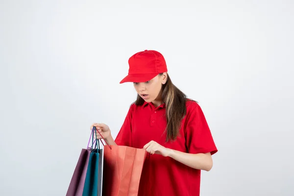 Kırmızı Tişörtlü Şapkalı Kız Alışveriş Torbalarıyla Poz Veriyor — Stok fotoğraf