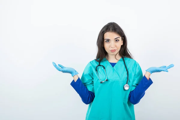 医療用手袋に立って聴診器を持つ若い看護師の肖像画 高品質の写真 — ストック写真