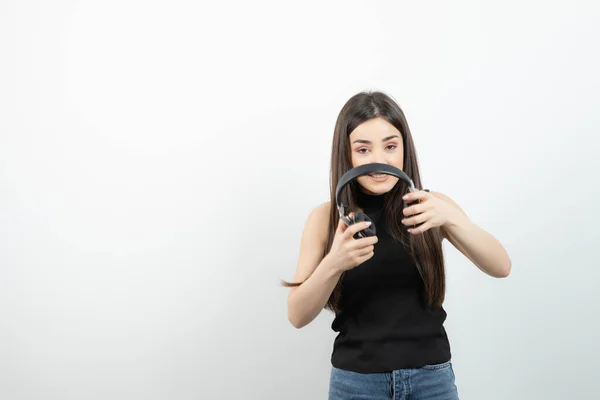 Retrato Una Mujer Joven Sosteniendo Auriculares Sobre Una Pared Blanca —  Fotos de Stock