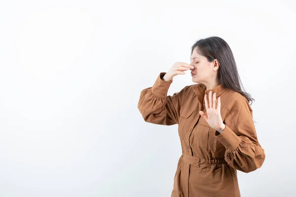 Imagem Modelo Bonito Mulher Segurando Mão Nariz Contra Parede Branca — Fotografia de Stock