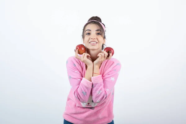 Foto Uma Jovem Pijama Segurando Duas Frutas Vermelhas Maçã Foto — Fotografia de Stock