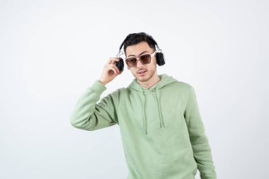 Genç yakışıklı bir adamın beyaza kulaklık takması. Yüksek kalite fotoğraf