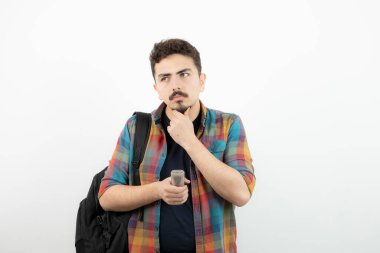 Sırt çantalı ve mikrofonlu dalgın yakışıklı bir adamın fotoğrafı. Yüksek kalite fotoğraf