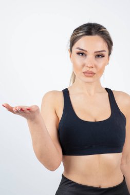 Siyah tarlada dikilmiş poz veren formda genç bir kadın resmi. Yüksek kalite fotoğraf