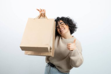 El işi çantalı güzel bir kadının baş parmağını kaldırması. Yüksek kalite fotoğraf