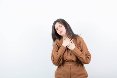 Beyaz duvara karşı el ele tutuşan esmer bir kadın modeli. Yüksek kalite fotoğraf